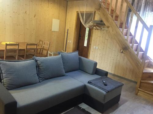 a living room with a couch and a staircase at Metsaääre Accommodation in Uulu