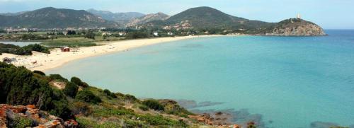 a beach with people on it with mountains in the background at Bithia Apartment in Chia