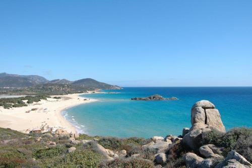 a view of a beach with rocks and the ocean at Bithia Apartment in Chia