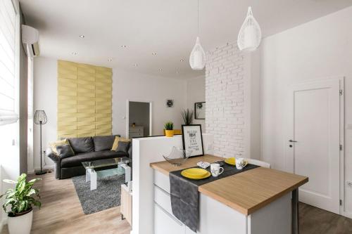 een keuken en een woonkamer met witte muren en een tafel bij Dohany 3 Synagogue Apartment in Boedapest