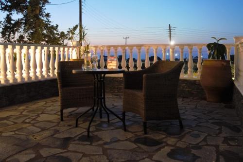 a table and chairs on a patio with a fence at Olympus Studios in Malia
