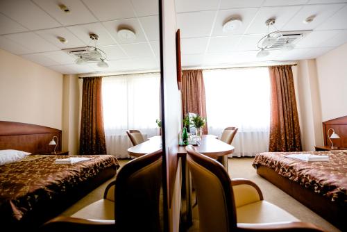a hotel room with two beds and a table and chairs at Hotel Stal in Stalowa Wola