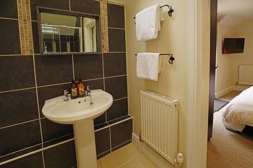a bathroom with a sink and a mirror at Greyhound Hever in Edenbridge