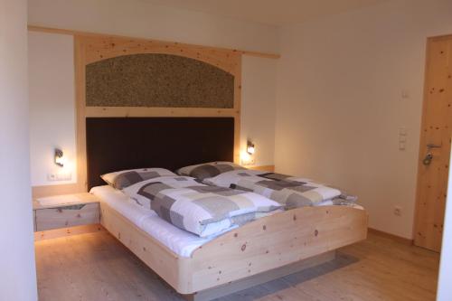 a bedroom with a wooden bed with a wooden headboard at Pension Baumgarten in Naturno