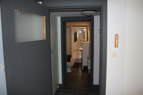a hallway with a door leading to a bathroom with a toilet at Lesse matinal in Redu