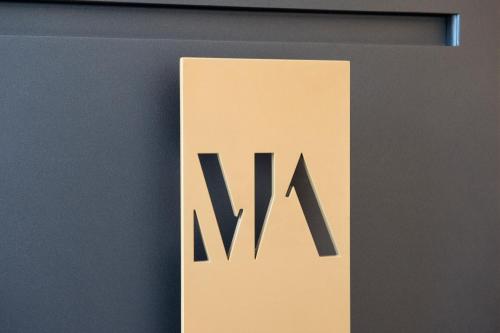 a sign with the letter m on a wall at Gatto Bianco Mia Aparthotel in Milan
