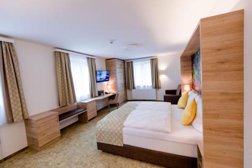 a hotel room with a bed and a television at R&R Residenzen HOTEL in Mitterbach