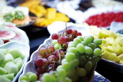 a bunch of grapes on a table with other fruits at Riu Plaza Guadalajara in Guadalajara