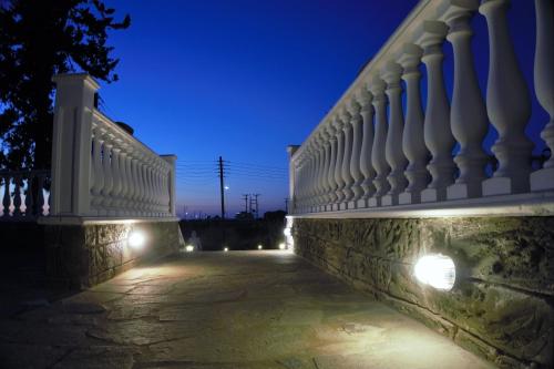 a stone fence with lights on it at night at Olympus Studios in Malia