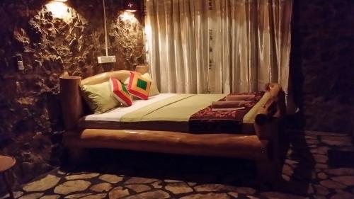 a bedroom with a bed with pillows on it at Lizard Safari Lodge in Udawalawe