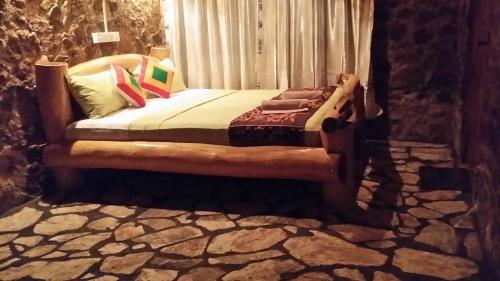 a bed sitting in a room with a window at Lizard Safari Lodge in Udawalawe