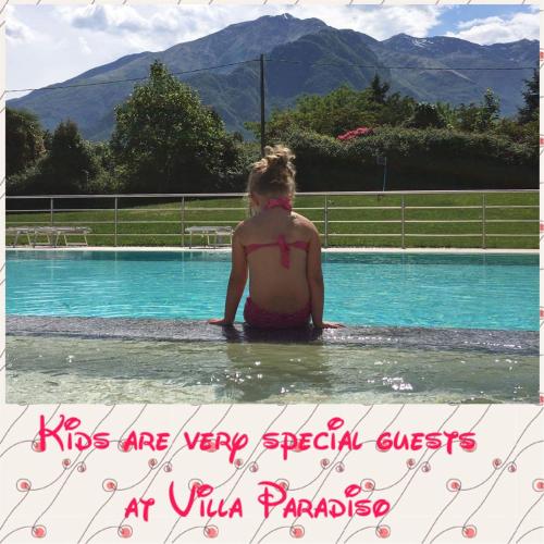 a woman sitting in the water in a swimming pool at Residence Villa Paradiso in Gravedona