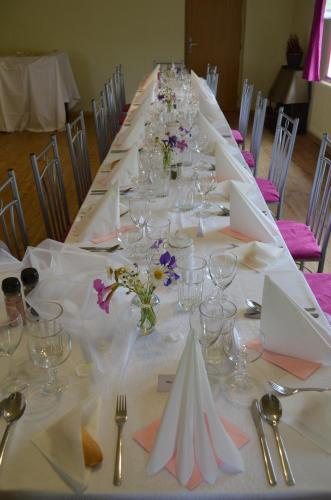 a long table with glasses and flowers on it at Ubytování - U nás doma in Orličky
