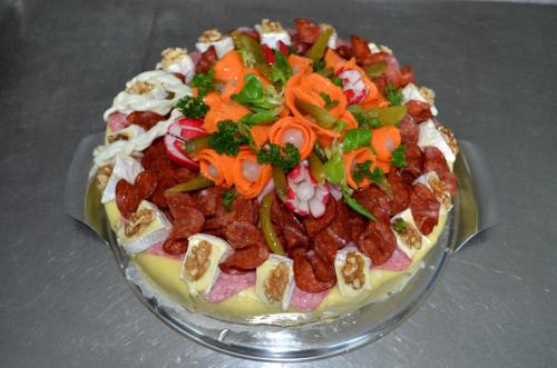 a cake on a glass plate with vegetables on it at Ubytování - U nás doma in Orličky