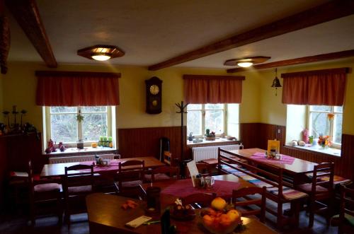 a dining room with tables and chairs and windows at Ubytování - U nás doma in Orličky
