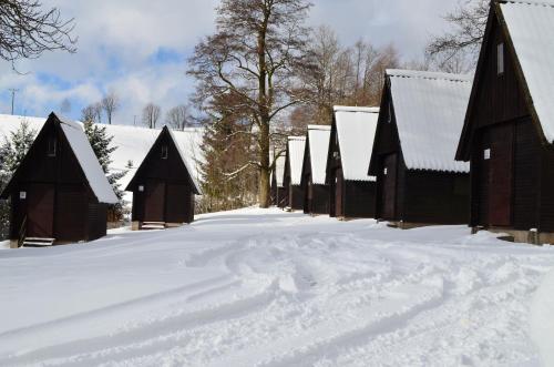 a row of barns covered in snow at Ubytování - U nás doma in Orličky