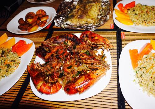 a table topped with plates of food with meat and rice at Sunset View Beach Hotel in Arugam Bay