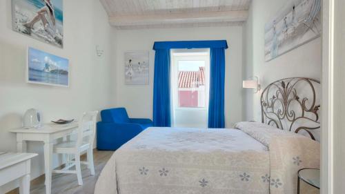 a bedroom with a bed and a table and a desk at Smart Suite & Apartments in Santa Teresa Gallura