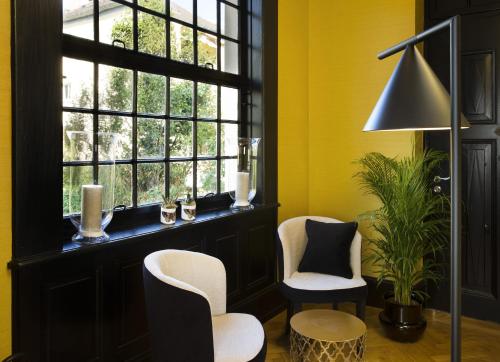una camera gialla con due sedie e una finestra di Boutique Hotel Des XV a Strasburgo