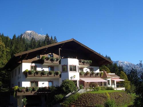 a large white building with potted plants on it at Gästehaus Kristall in Kleinarl