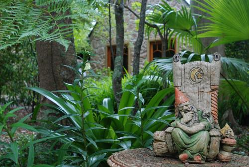 a gnome sitting on a bench in a garden at Witches Falls Cottages in Mount Tamborine