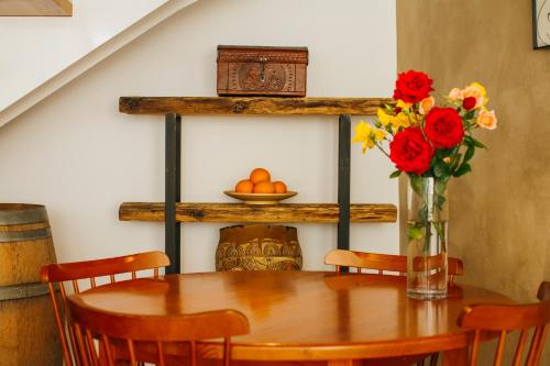 a dining room table with a vase of flowers on it at La Casa dels Abeuradors in Gandesa