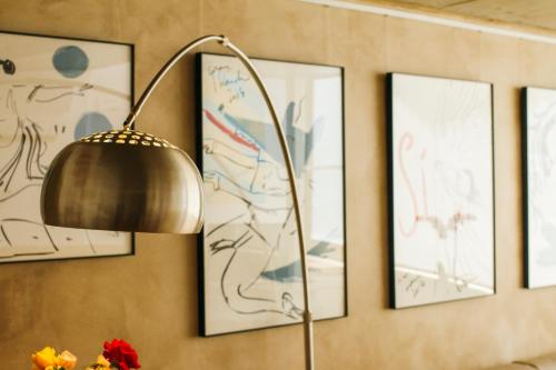 a lamp in a room with pictures on the wall at La Casa dels Abeuradors in Gandesa