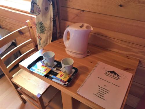 a table with a tea pot and two cups on it at Chalet Saint Bernard in Montgenèvre