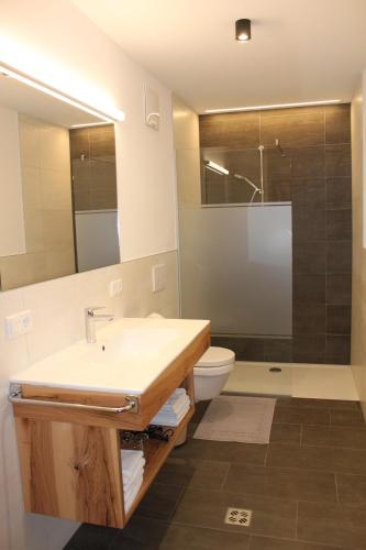 a bathroom with a sink and a toilet and a mirror at Pension Baumgarten in Naturno