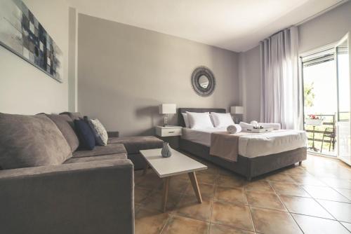 a living room with a couch and a bed at Teatro Deluxe Rooms in Kato Rodini