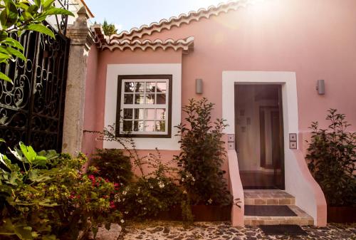 a pink house with a door and a gate at Villa Marquês near Tejo River in Cruz Quebrada