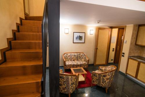 a lobby with two chairs and a stair case at Le Petit Hotel in Turin