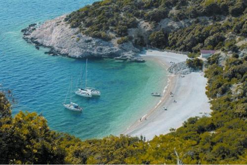 dos barcos sentados en el agua en una playa en Apartment Anetica en Cres