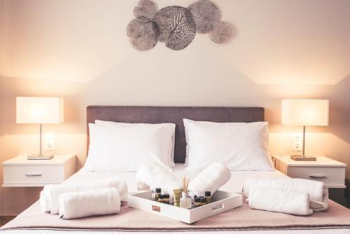 a bedroom with a bed with white pillows and two lamps at Teatro Deluxe Rooms in Kato Rodini