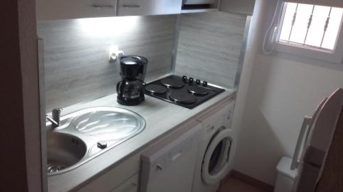 - une cuisine avec évier et cafetière sur un comptoir dans l'établissement Les Andalouses, au Cap d'Agde