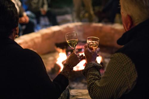two people holding up wine glasses in front of a fire at Joshua Creek Ranch in Boerne