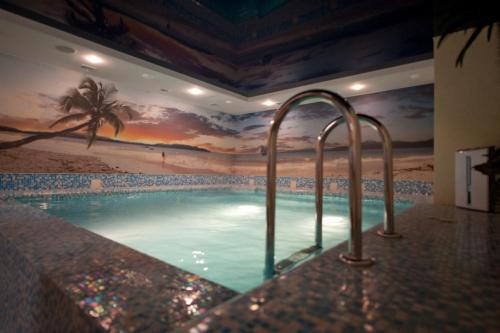 a swimming pool with a mural of a beach at Deluxe Hotel Kupava in Lviv