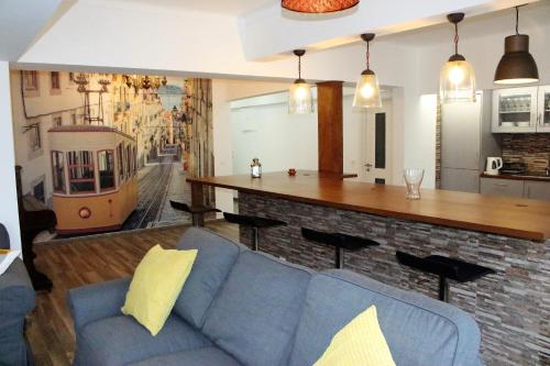 a living room with a blue couch and a bar at Santos Deluxe Apartment in Lisbon