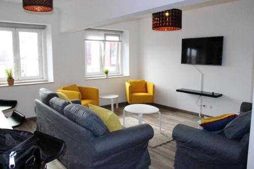 a living room with couches and chairs and a tv at Santos Deluxe Apartment in Lisbon