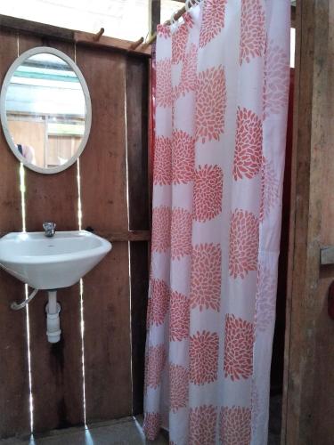 a bathroom with a shower curtain and a sink at Jungle Wolf Expeditions Lodge & Tours Iquitos in Yucuruche