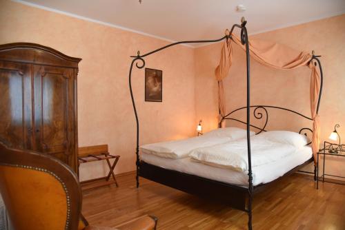 een slaapkamer met een hemelbed en een stoel bij Schlafen in Weimar in Weimar