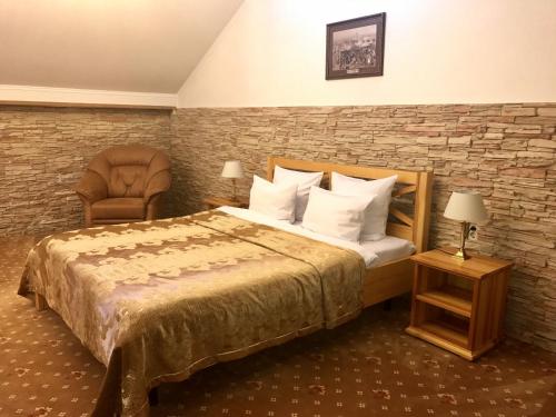 une chambre d'hôtel avec un lit et une chaise dans l'établissement Guest House Sibirskiy, à Tcheliabinsk