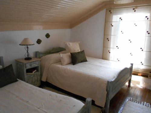 a bedroom with two beds and a window at Casa da Avó Teresinha in Sabugueiro