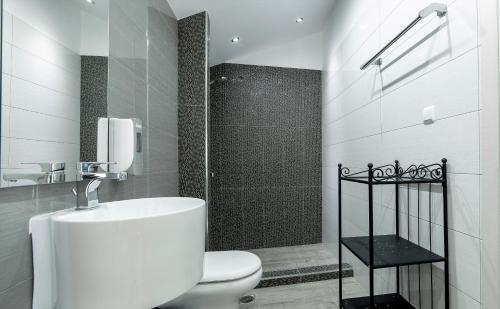 a white bathroom with a toilet and a shower at Liberte Maisonettes in Parga