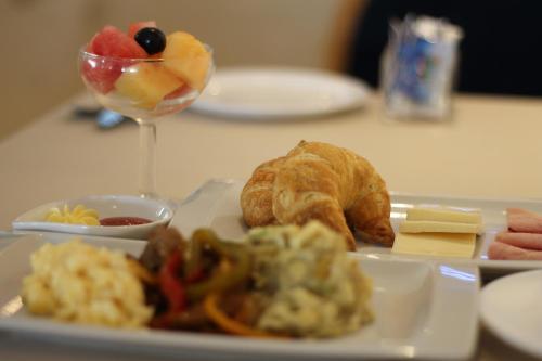 a plate of food with bread and fruit on a table at Hotel Ramada in Guayaquil
