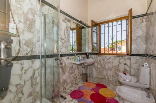 a bathroom with a shower and a toilet and a sink at Villa Pallina with Pool - Happy Rentals in Massarosa