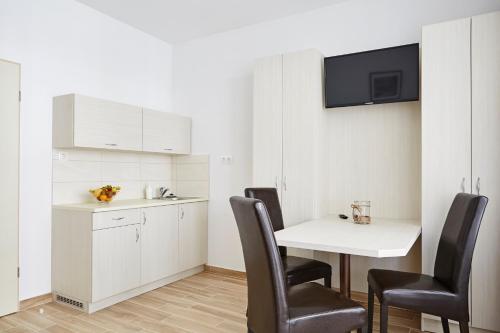 a small kitchen with a white table and chairs at Hotel Astoria in Balatonfüred