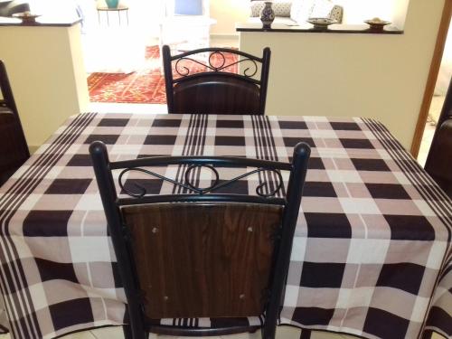 a table with two chairs and a checkered table cloth at Résidence La Galiote in Essaouira