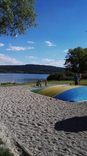 a group of people standing on a beach near a body of water at Apartmány Nová Pec in Nová Pec