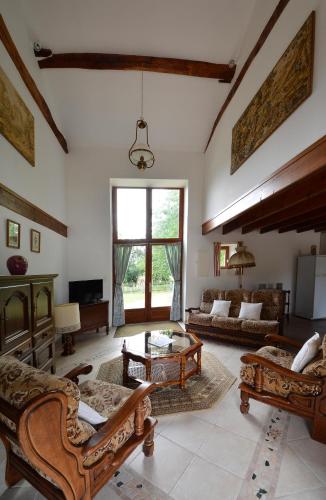 Elle comprend un salon doté de meubles et d'une grande fenêtre. dans l'établissement Gites dans les Champs, à Sauzé-Vaussais